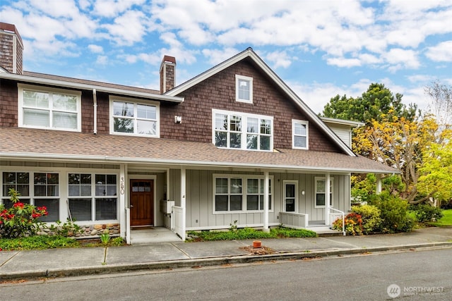 350 Castellano Way Unit 204, Port Townsend, WA 98368 - view of front of property with board and batten siding, roof with shingles, a chimney, and covered porch