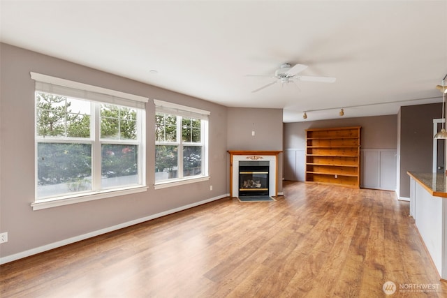 350 Castellano Way Unit 204, Port Townsend, WA 98368 - unfurnished living room with a fireplace with flush hearth, light wood-style flooring, baseboards, a ceiling fan, and track lighting