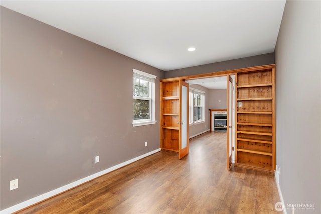 350 Castellano Way Unit 204, Port Townsend, WA 98368 - unfurnished living room featuring a fireplace, wood finished floors, baseboards, and recessed lighting