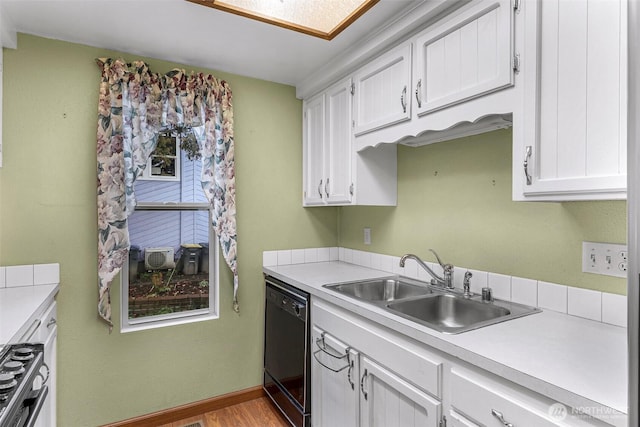 kitchen with white cabinets, black dishwasher, light countertops, and a sink
