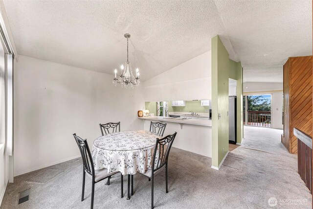 dining room featuring carpet, a textured ceiling, and an inviting chandelier