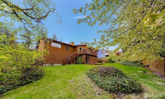 view of yard featuring fence, a deck, and stairs