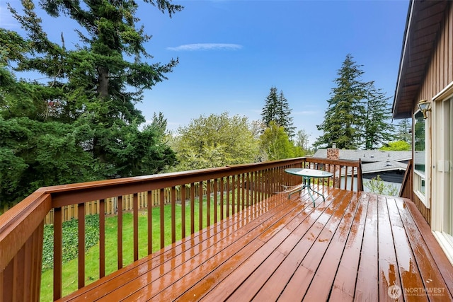wooden terrace featuring a lawn