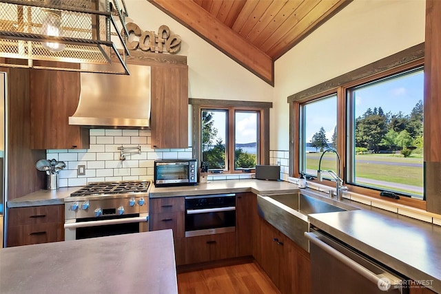 335 Blakely Dr, Blakely Island, WA 98222 - kitchen with stainless steel appliances, lofted ceiling, modern cabinets, a sink, and backsplash