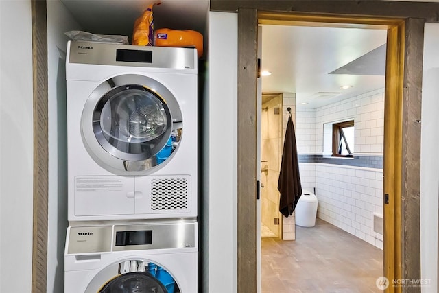 335 Blakely Dr, Blakely Island, WA 98222 - washroom with stacked washing machine and dryer, tile walls, and tile patterned floors