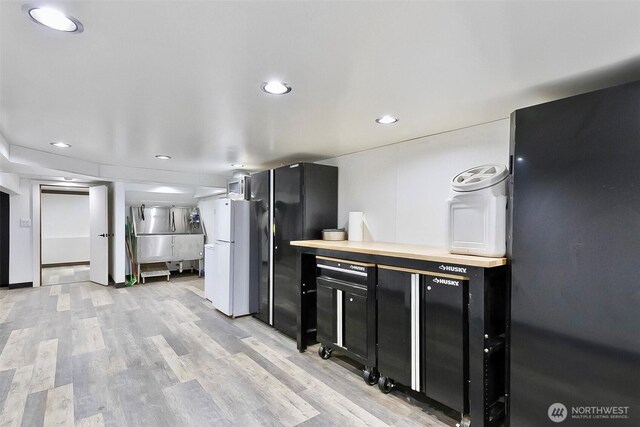 335 Blakely Dr, Blakely Island, WA 98222 - kitchen with light wood finished floors, recessed lighting, freestanding refrigerator, and light countertops