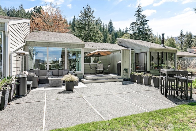 rear view of house with a patio, outdoor dining area, and an outdoor living space with a fire pit