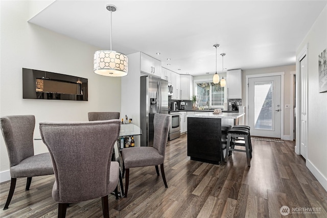 dining space with baseboards and dark wood-style floors