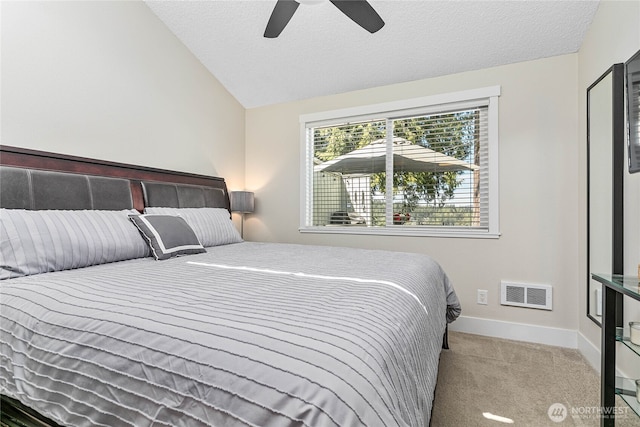 carpeted bedroom with visible vents, lofted ceiling, baseboards, a textured ceiling, and a ceiling fan
