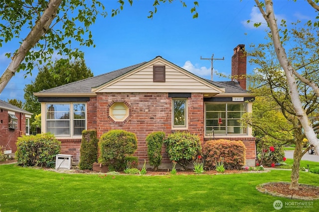 view of front of home with brick siding, a chimney, and a front yard
