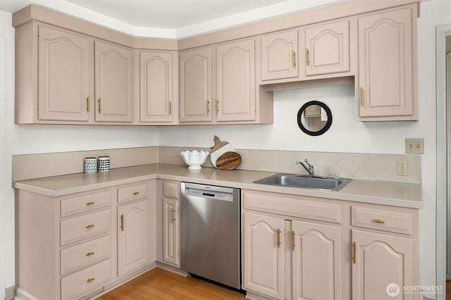 kitchen featuring cream cabinets, a sink, light wood-style floors, light countertops, and stainless steel dishwasher