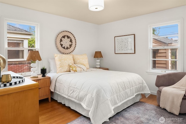 bedroom with baseboards and wood finished floors