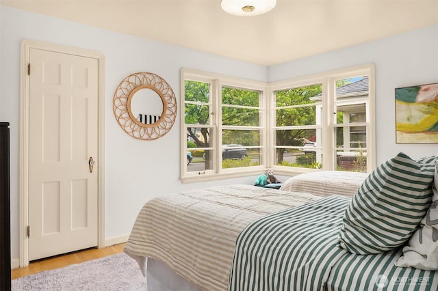 bedroom with baseboards and wood finished floors