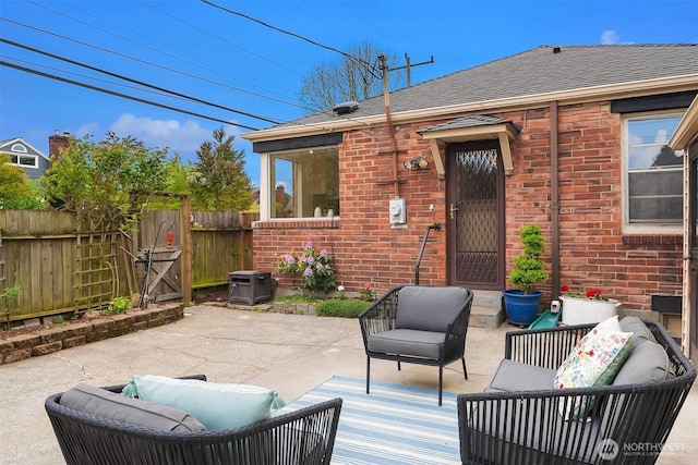 view of patio with fence, outdoor lounge area, and central AC unit