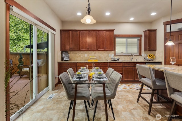 19301 87th Avenue Ct E, Graham, WA 98375 - kitchen with a sink, visible vents, backsplash, light stone countertops, and hanging light fixtures