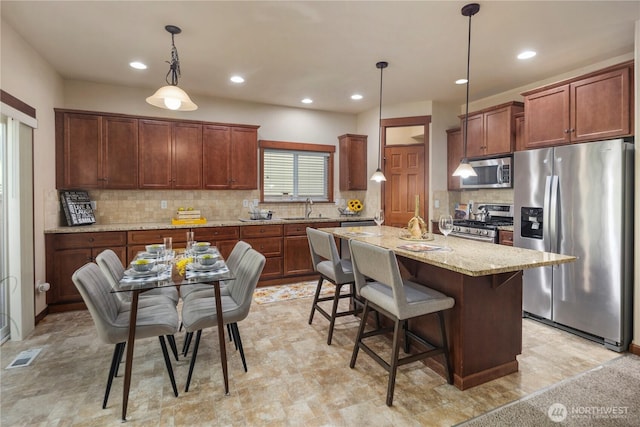 19301 87th Avenue Ct E, Graham, WA 98375 - kitchen featuring light stone counters, stainless steel appliances, backsplash, visible vents, and a sink