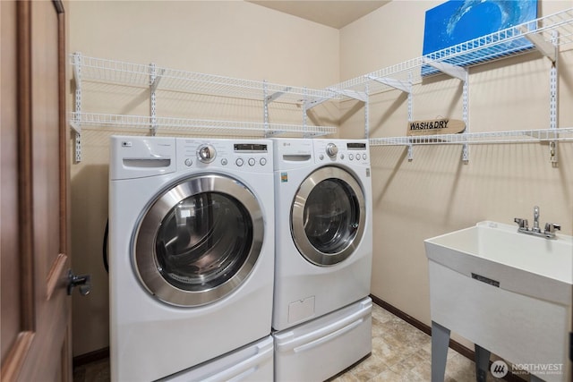 19301 87th Avenue Ct E, Graham, WA 98375 - clothes washing area featuring baseboards, a sink, independent washer and dryer, and laundry area