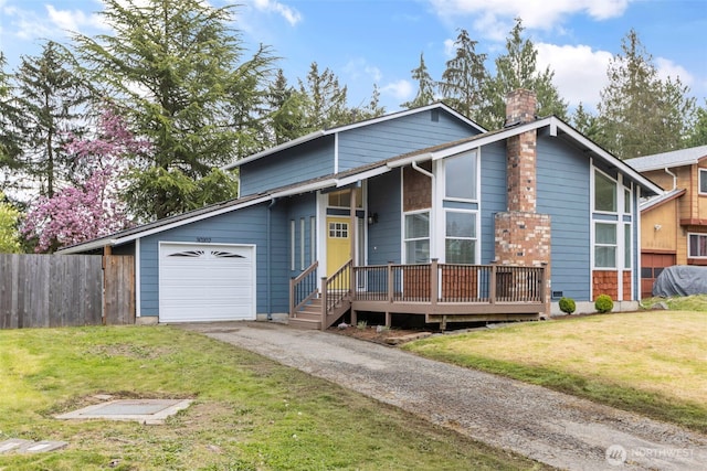 view of front of house featuring a chimney, fence, driveway, a front yard, and a garage