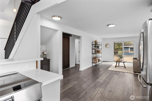 kitchen with range with electric cooktop, light countertops, baseboards, dark wood-type flooring, and freestanding refrigerator