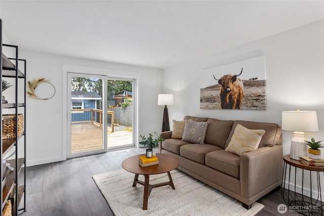 living area with baseboards and wood finished floors