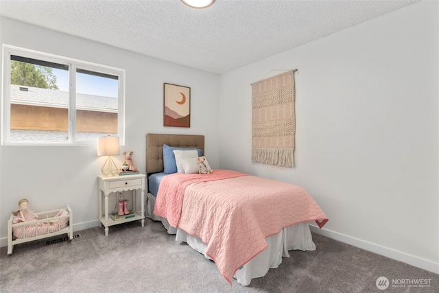 carpeted bedroom featuring baseboards and a textured ceiling