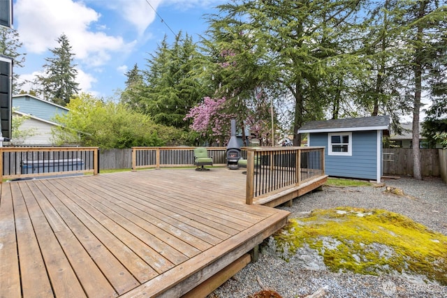 deck with an outbuilding, a shed, and a fenced backyard
