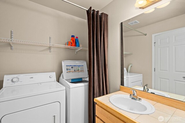 laundry room featuring a sink, visible vents, laundry area, and washer and clothes dryer