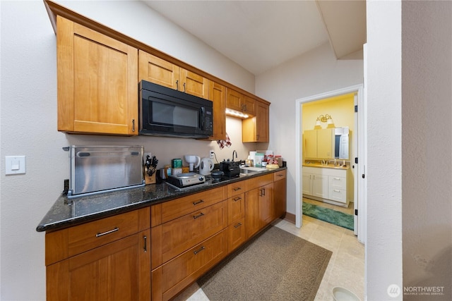 12724 Marine Dr, Anacortes, WA 98221 - kitchen featuring black microwave, dark stone counters, brown cabinetry, and a sink