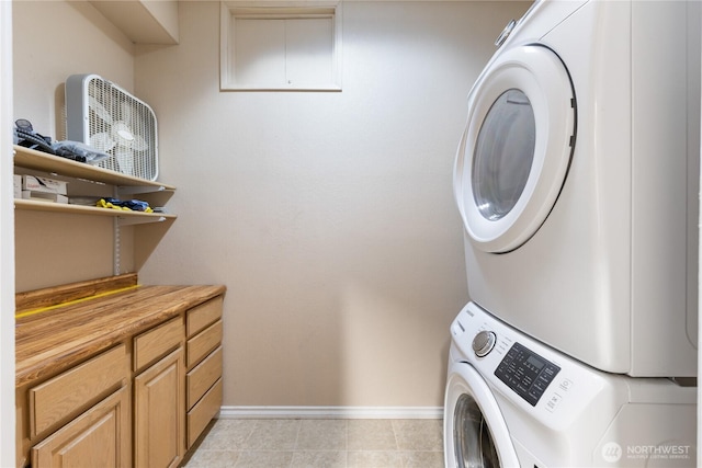 12724 Marine Dr, Anacortes, WA 98221 - laundry room with cabinet space, stacked washer and dryer, and baseboards