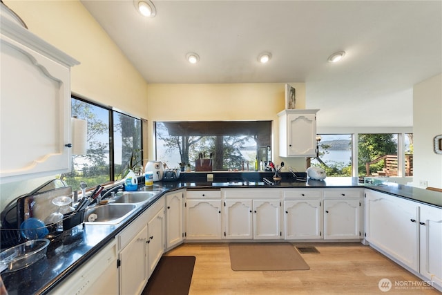 12724 Marine Dr, Anacortes, WA 98221 - kitchen with dark countertops, a wealth of natural light, white cabinetry, and a sink