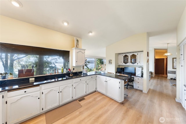 12724 Marine Dr, Anacortes, WA 98221 - kitchen featuring dark countertops, visible vents, a peninsula, light wood-style flooring, and white cabinetry