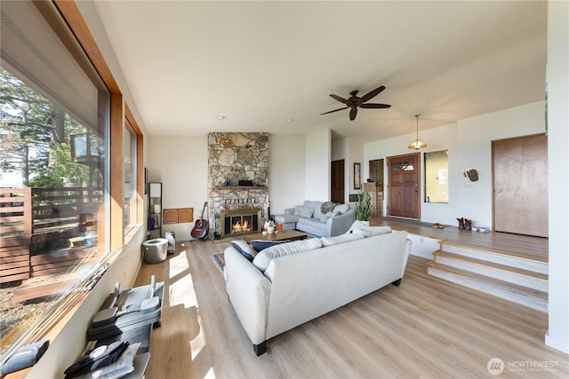 12724 Marine Dr, Anacortes, WA 98221 - living area featuring light wood-style flooring, a stone fireplace, and ceiling fan