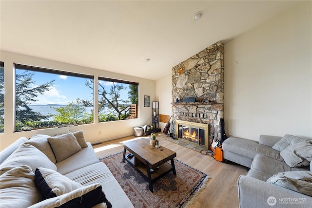 12724 Marine Dr, Anacortes, WA 98221 - living room featuring a fireplace, vaulted ceiling, and light wood-type flooring