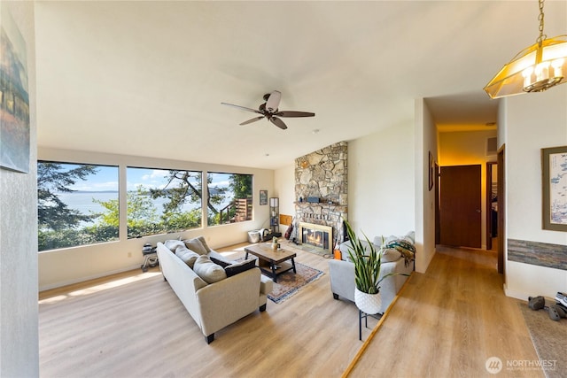 12724 Marine Dr, Anacortes, WA 98221 - living area featuring baseboards, a ceiling fan, wood finished floors, and a stone fireplace