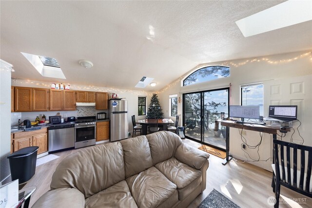 12724 Marine Dr, Anacortes, WA 98221 - living area with vaulted ceiling with skylight and light wood finished floors