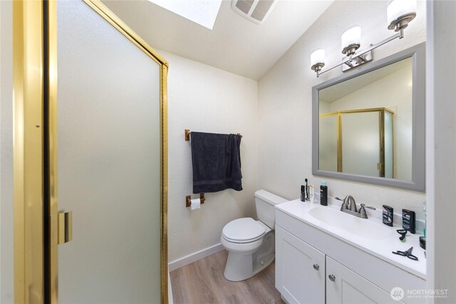 12724 Marine Dr, Anacortes, WA 98221 - full bath with a shower stall, wood finished floors, vanity, toilet, and visible vents
