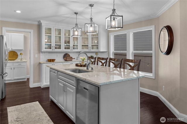 kitchen with white cabinets, decorative backsplash, appliances with stainless steel finishes, and a sink
