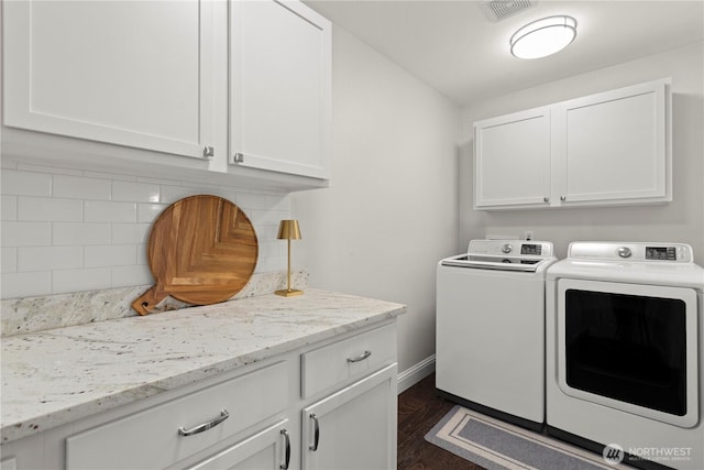 washroom with cabinet space, independent washer and dryer, visible vents, and baseboards