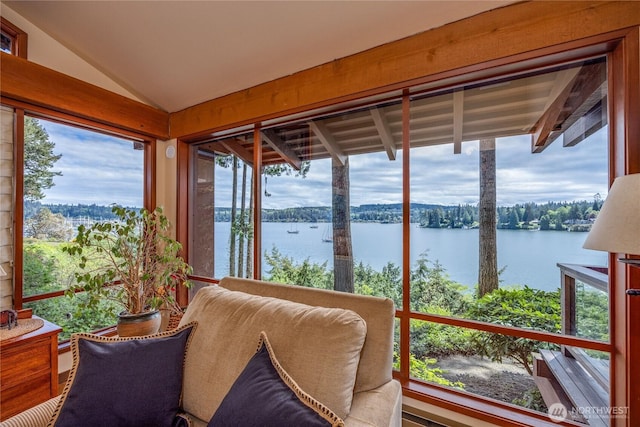 sunroom / solarium featuring a water view and vaulted ceiling