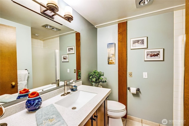 bathroom with toilet, vanity, tile patterned floors, and a shower
