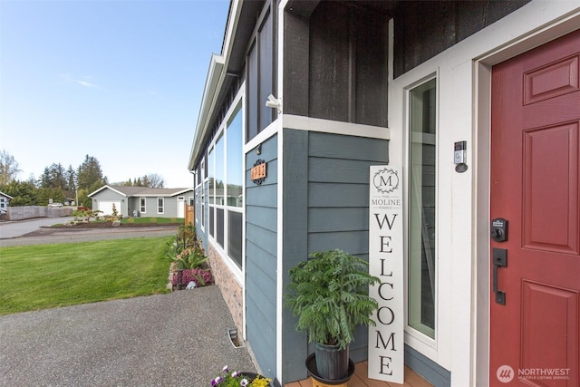 view of exterior entry with a yard