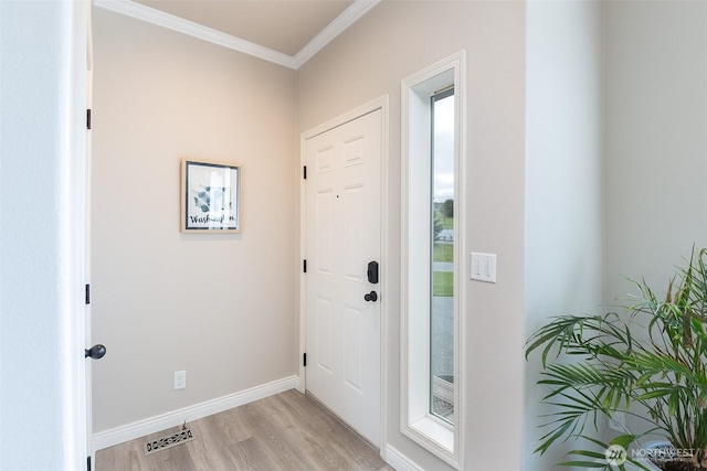 doorway with baseboards, visible vents, ornamental molding, and light wood-style floors