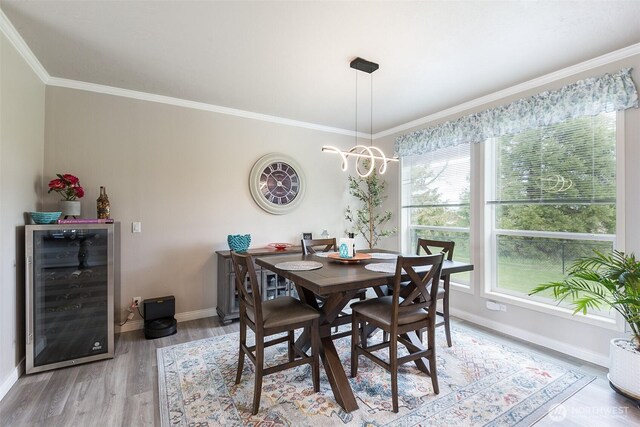 dining area with beverage cooler, plenty of natural light, light wood-style flooring, and baseboards