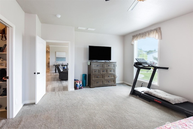 exercise room featuring carpet flooring, ceiling fan, and baseboards