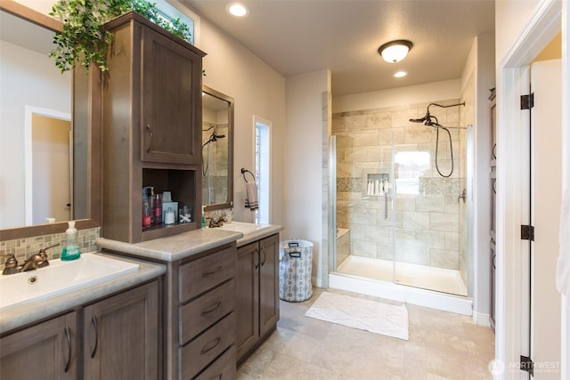 full bathroom featuring tasteful backsplash, recessed lighting, tile patterned flooring, vanity, and a stall shower