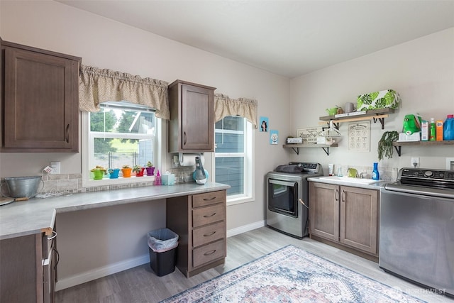 kitchen with washer and clothes dryer, open shelves, light wood-type flooring, dark brown cabinetry, and light countertops
