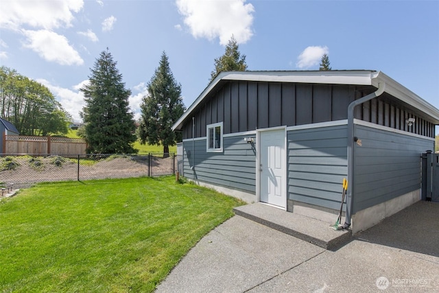 view of home's exterior featuring fence, board and batten siding, and a yard