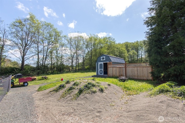 view of yard featuring fence, a shed, and an outbuilding