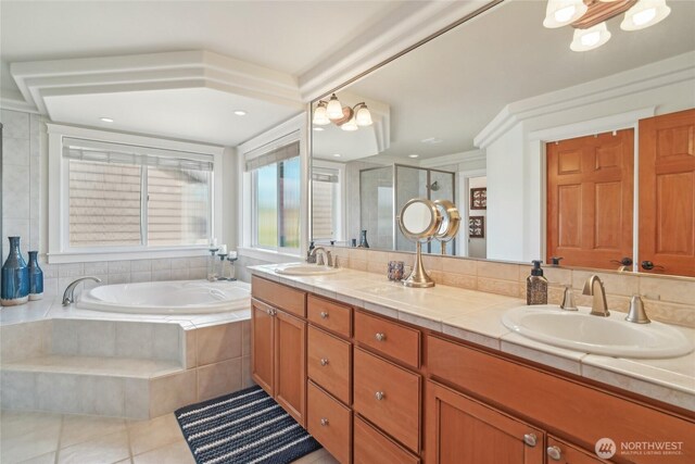 bathroom with a stall shower, double vanity, a sink, and a bath