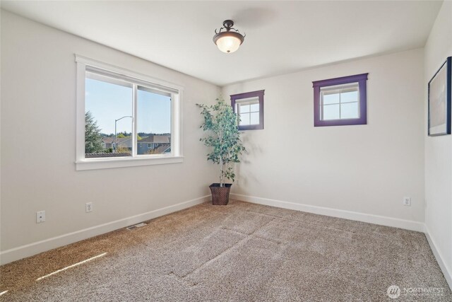 unfurnished room featuring baseboards, carpet flooring, and visible vents